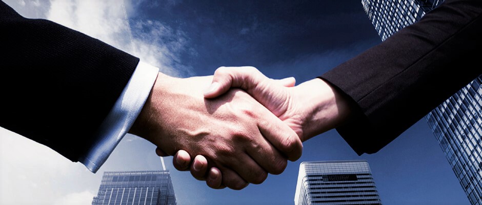 Business handshake with a city skyline in the background, symbolizing a support partnership.