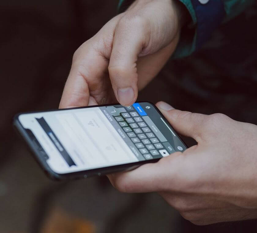 Close-up of a person typing on a smartphone.