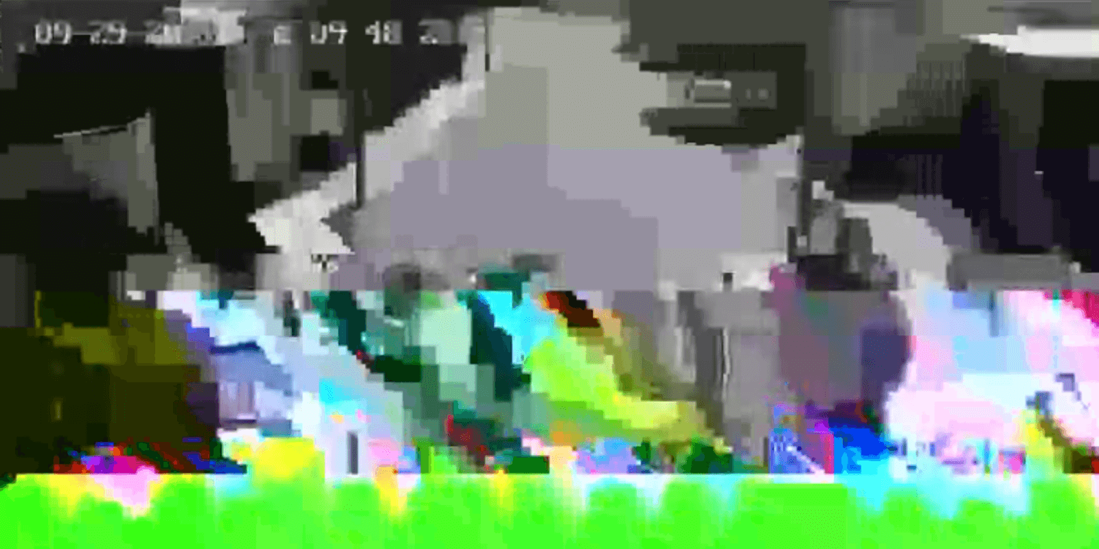 Screenshot of a corrupted video stream showing severe color and pixelation glitches, with a security-camera timestamp overlay -- an example of the streaming errors this project addressed.